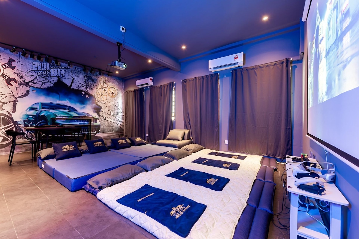 Ein Zimmer mit einem großen Bett, einem Schreibtisch, einem Projektor und Wandgemälde.