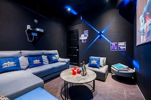 A modern lounge area with a grey sofa, a round coffee table, and a small armchair.