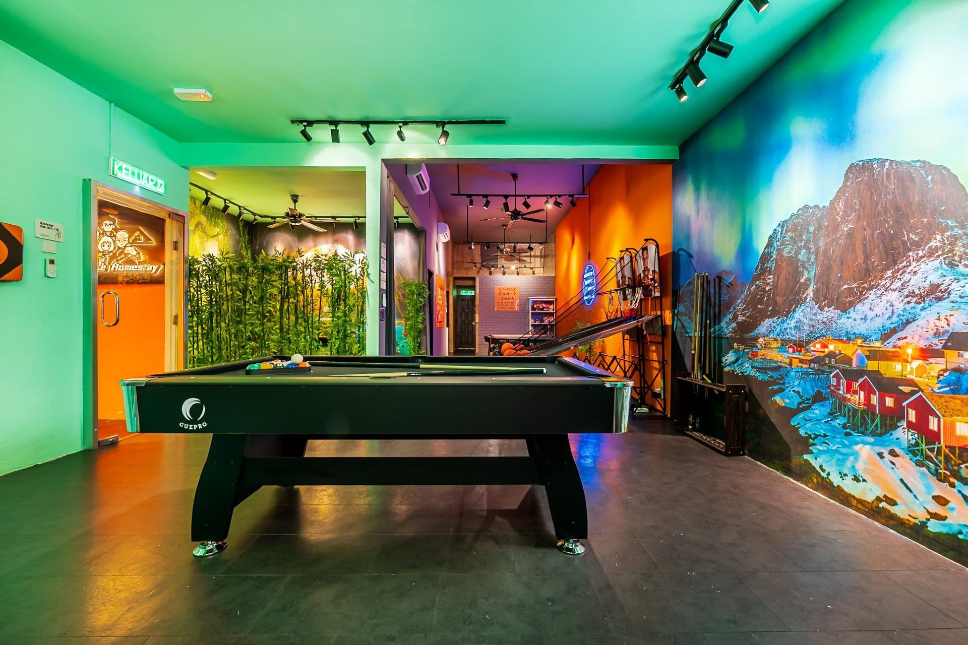 A billiards table in a room with a mural of a snowy village on the wall.