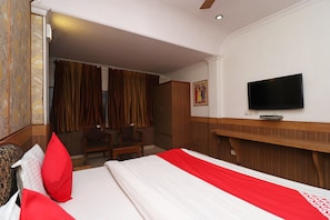 A hotel room with a bed, a TV, a desk, and a chair. - Hotel O by OYO Highway Inn International (Kolkata)