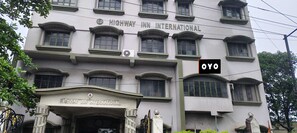 Un edificio con el letrero 'HIGHWAY INN INTERNATIONAL' y una señal más pequeña 'OYO' al costado.