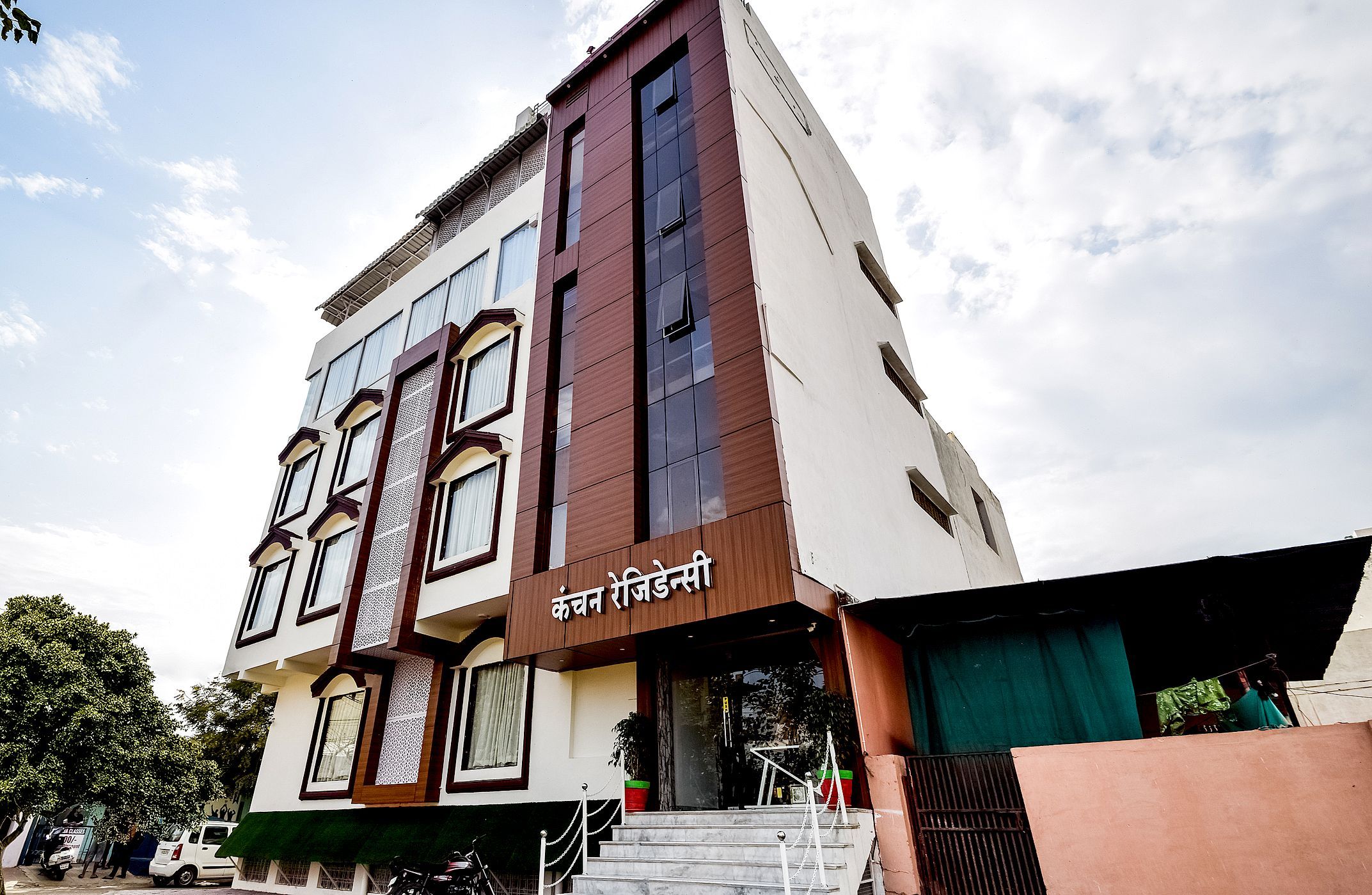 A multi-story building with a modern architectural design, featuring a prominent entrance with steps and a glass facade.
