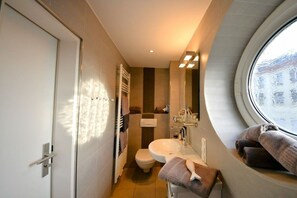 Une petite salle de bain comprenant des toilettes, un lavabo et un porte-serviettes.