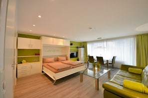 Un appartement moderne comprenant un lit, un canapé, une table à manger et un téléviseur.