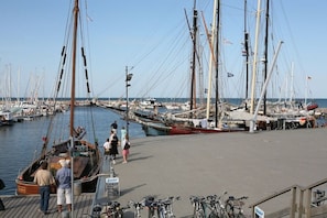 A marina with multiple boats docked, a wooden pier, and bicycles parked. - Holiday apartment with 1 bedroom (Kühlungsborn)