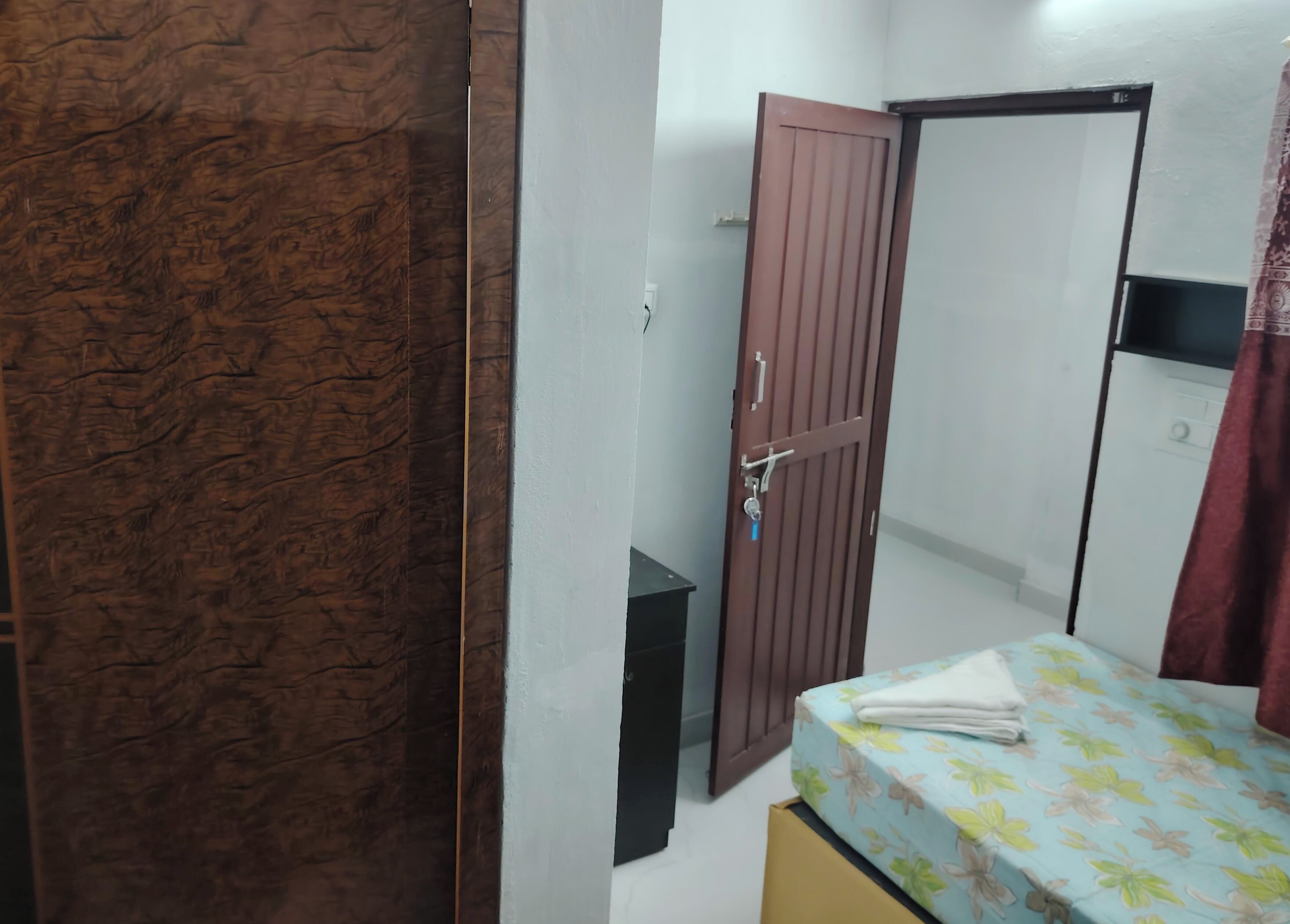 A bedroom with a bed, a wardrobe, and a door.