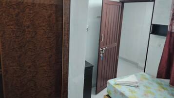 A bedroom with a bed, a wardrobe, and a door.