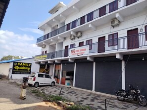 Un edificio a più piani con un cartello che indica 'FAMILY Residency', con indicazione di camere con e senza aria condizionata.
