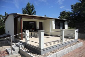 Un bâtiment moderne doté d’un espace extérieur couvert, d’un escalier et d’une rambarde.