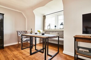 A living room with a sofa, a table, and a television. - Holiday apartment in Hörnum with Wi-Fi (Hörnum)