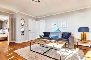 A modern living room with a grey sofa, a coffee table, and a lamp. - Holiday apartment in Hörnum with Wi-Fi (Hörnum)