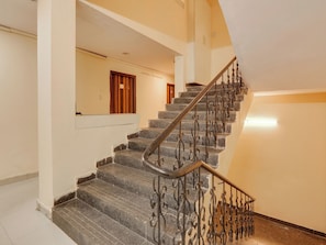 A staircase with a metal railing and a wooden door at the top. - HOTEL O New R Inn (Hyderabad)