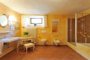 Ein Badezimmer mit Waschbecken, Waschtisch, Toilette, Bidet und einer Duschkabine.