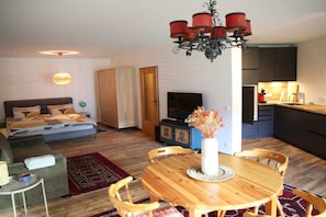 A compact living space with a bed, sofa, dining table, and kitchenette. - Holiday apartment with 1 bedroom (Füssen)