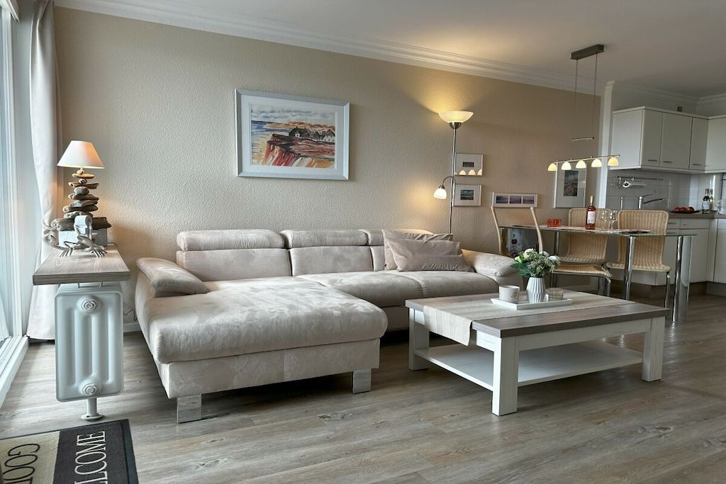 A modern living room with a sofa, coffee table, and a painting on the wall.