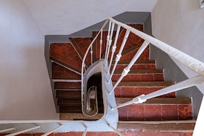 Una escalera de caracol con barandillas blancas y escalones de ladrillo rojo.