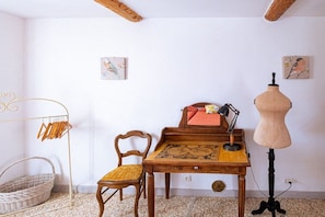 A room with a wooden table, a chair, a mannequin, and a wall-mounted rack. - Cabin with 2 bedrooms (Saint Saturnin lès Apt)
