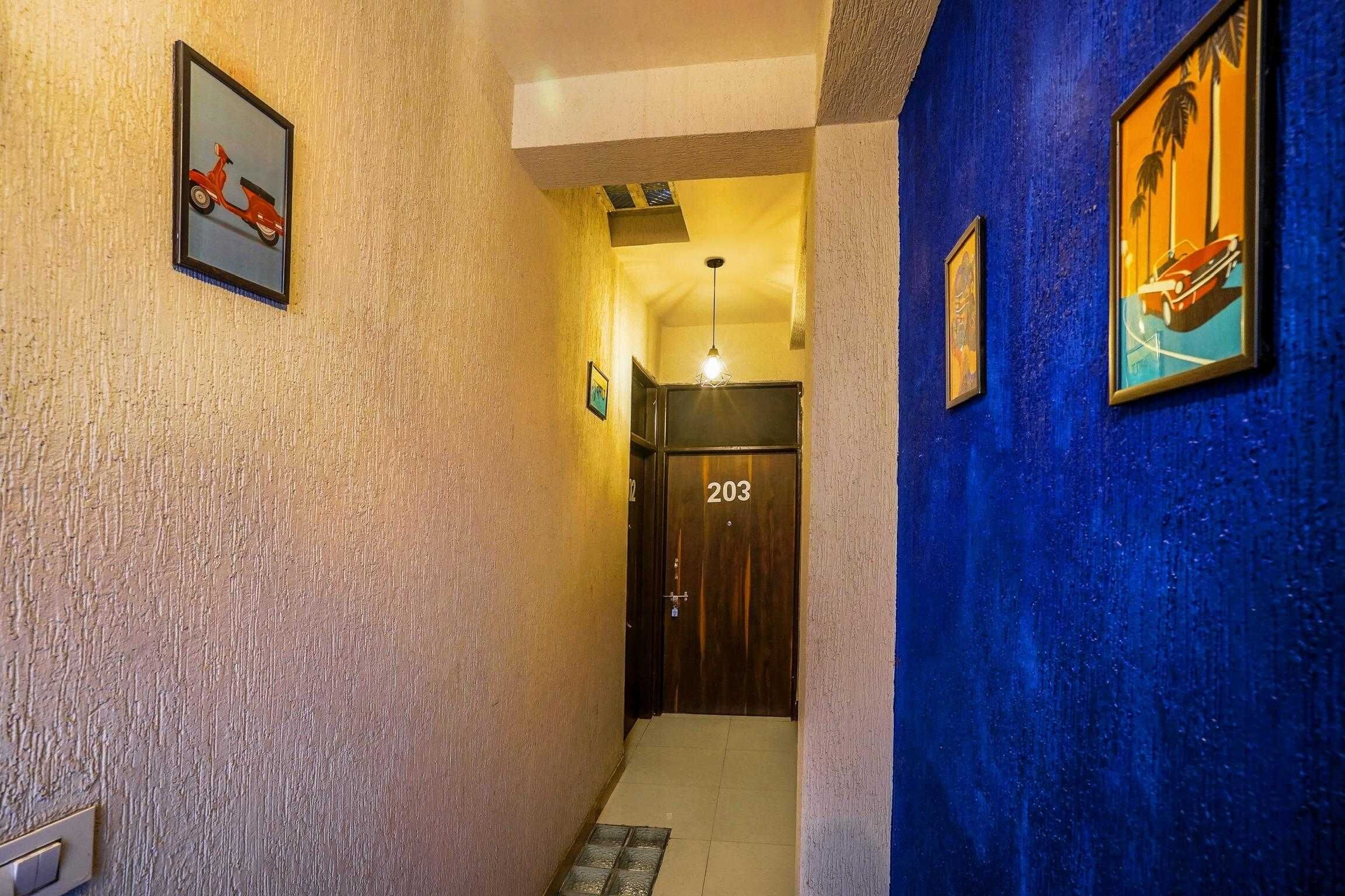 Un pasillo con una puerta que tiene la etiqueta '203' y una lámpara sobre ella.