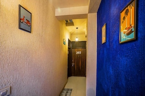 Corredor com uma porta identificada com o número '203' e um luminário acima.