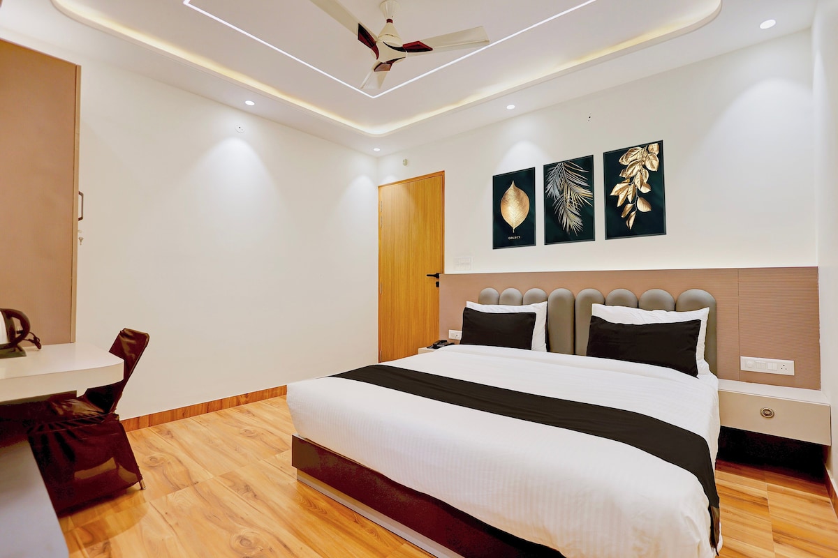 A modern bedroom with a bed, bedside tables, a desk, and a chair.