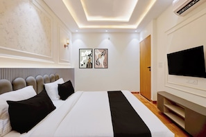 Una camera da letto moderna con un letto grande, una televisione a schermo piatto e un armadio in legno.