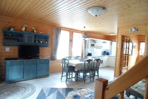 A wooden interior with a dining area, kitchen, and a staircase. - Hasselfelde House 24 (Hasselfelde)