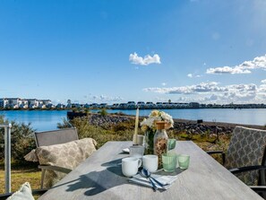 Ein Tisch im Freien mit Blick auf ein Gewässer und Gebäude in der Ferne.