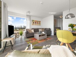 A modern living room with a sofa, coffee table, and a yellow chair. - Holiday Apartment With 2 Bedrooms (Kappeln)