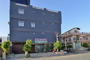 Un hotel a più piani con un cartello che indica la disponibilità di camere e un ristorante.