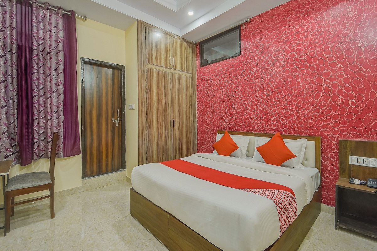 Una camera da letto con un letto, una sedia, un armadio e una parete decorata con un motivo rosso.