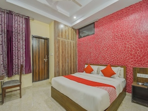 Una camera da letto con un letto, una sedia, un armadio e una parete decorata con un motivo rosso.