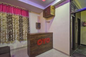 Una reception con la scritta 'OYO', un estintore e una porta a destra.
