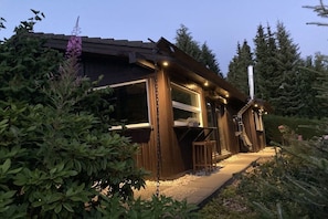 A wooden cabin with large windows, a chimney, and a pathway leading to the entrance. - Holiday home with 3 bedrooms (Winterberg)