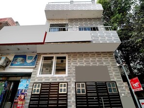 Un edificio de varios pisos con fachada de ladrillo, una ventana visible y un cartel anunciando servicios de banda ancha.