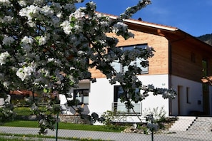 Ein modernes, zweistöckiges Gebäude mit Holzfassade und großen Fenstern.