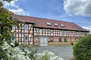 Ein traditionelles Fachwerkhäuschen mit rotem Ziegeldach, zahlreichen Fenstern und einem verschlossenen Eingang.