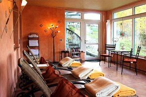 A room with a massage chair, a small table with a chair, and a window with a view of the outdoors. - Holiday apartment with 1 bedroom (Bodenmais)