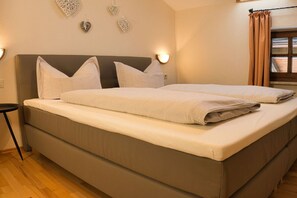 A double bed with a headboard, two bedside tables, and decorative wall art. - Holiday apartment with 1 bedroom (Bodenmais)