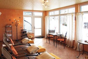 A room with a sunlit interior, a dining area, and a view of the outdoors. - Holiday apartment with 2 bedrooms (Bodenmais)