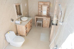 A bathroom with a toilet, sink, vanity, and shower. - 69 Resort Nusa Penida by Loccal Collection (Penida Island)