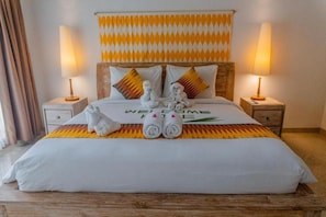 A hotel room with a bed, two nightstands, a welcome mat, and towels. - 69 Resort Nusa Penida by Loccal Collection (Penida Island)
