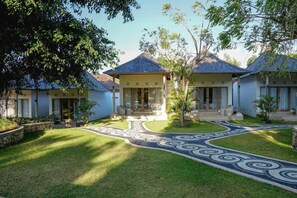 A traditional-style building with a central entrance, surrounded by a well-maintained lawn and decorative pathway. - 69 Resort Nusa Penida by Loccal Collection (Penida Island)