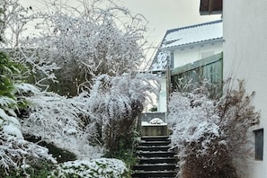 A snow-covered outdoor staircase leading to a building with a tiled roof. - Holiday apartment with 2 bedrooms (Tettnang)
