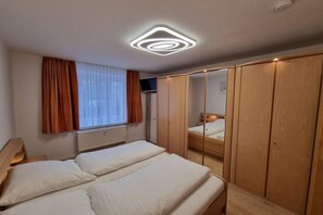 A bedroom with a bed, a wardrobe, and a mirror. - Holiday apartment with 2 bedrooms (Kurort Oberwiesenthal)
