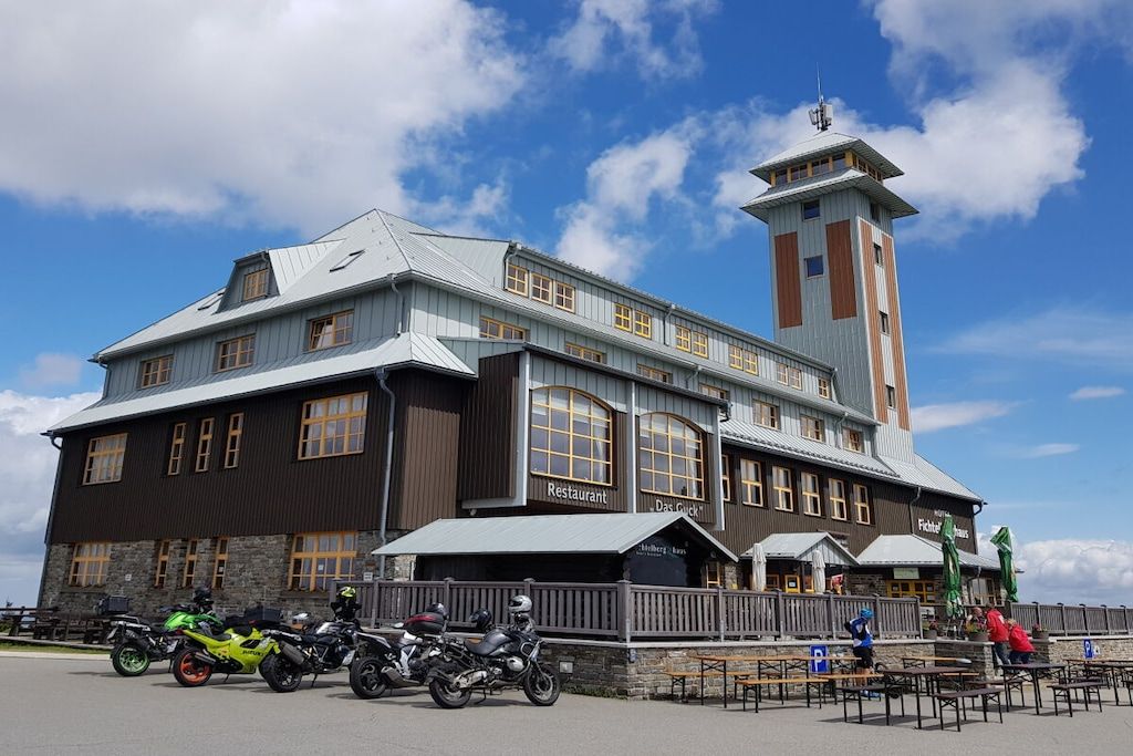 Un grand bâtiment abritant un restaurant et une tour, avec des motos garées devant.