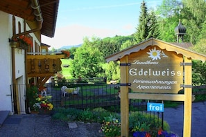 A wooden sign with 'Landhaus Edelweiss Ferienwohnungen Apartments' and a small lamp on top. - Holiday apartment with 2 bedrooms (Ofterschwang)