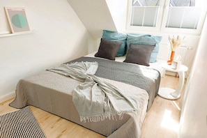 A bedroom with a bed, pillows, a bedside table, and a window. - Holiday home in Maasholm with swimming pool (Maasholm)
