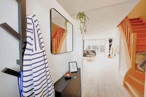 A modern interior with a staircase, a mirror, a framed picture, and a hanging plant. - Holiday home in Maasholm with swimming pool (Maasholm)