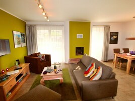 Una sala de estar con sofá, mesa de centro y chimenea.