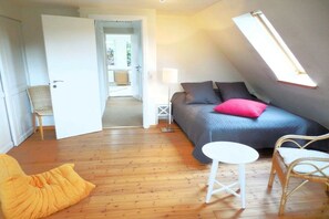A bedroom with a bed, a chair, a small table, and a skylight. - Holiday home with 3 bedrooms (Westerholz)